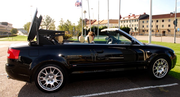 Black convertible in an empty parking lot.