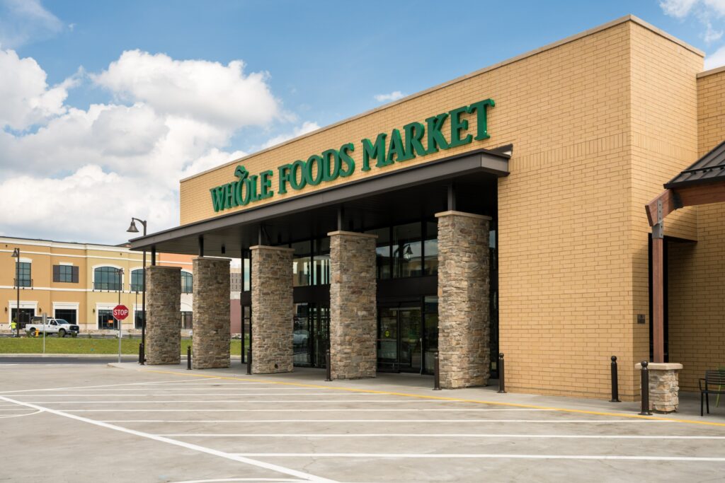 Photo of a brick building with "Whole Foods Market" written in green