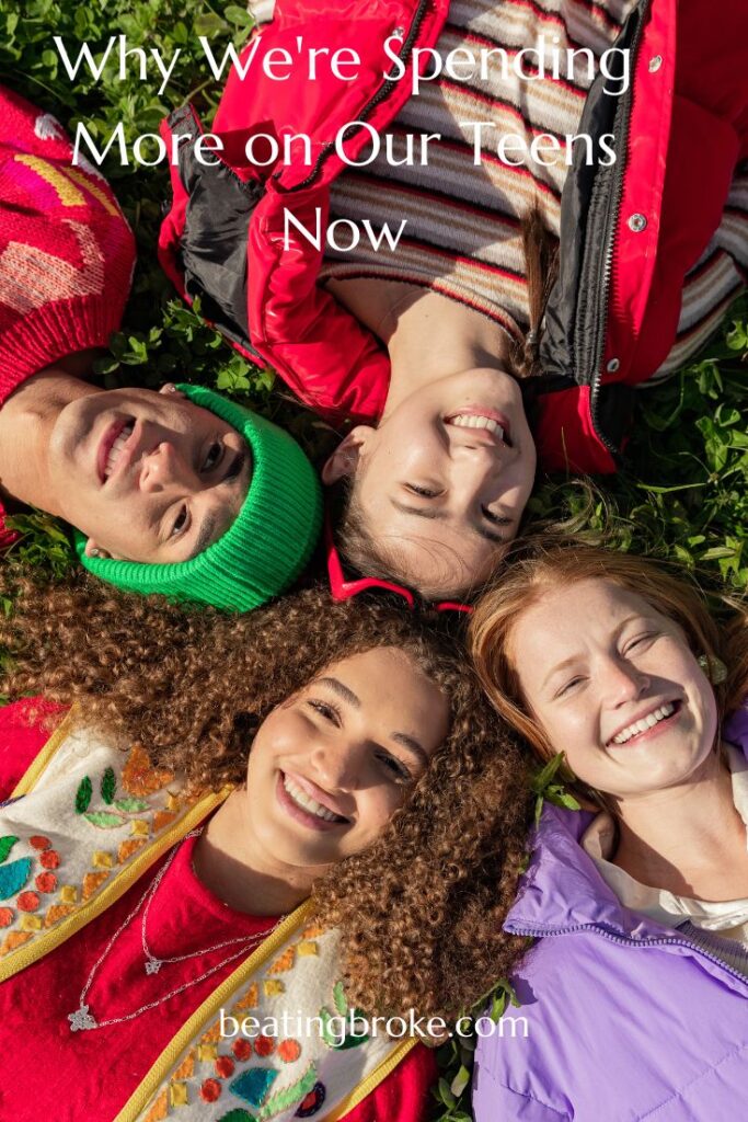 Teens laying on the ground in a circle with their heads together looking up and smiling