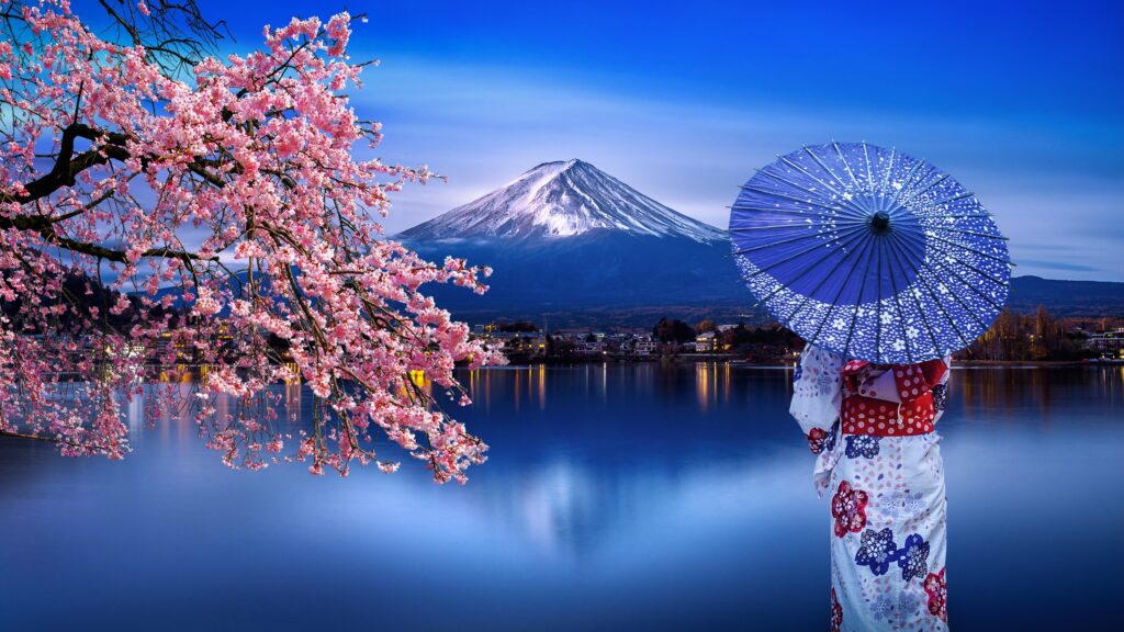 Mount Fuji in the background with a woman in a kimono facing the mountain in the foreground
